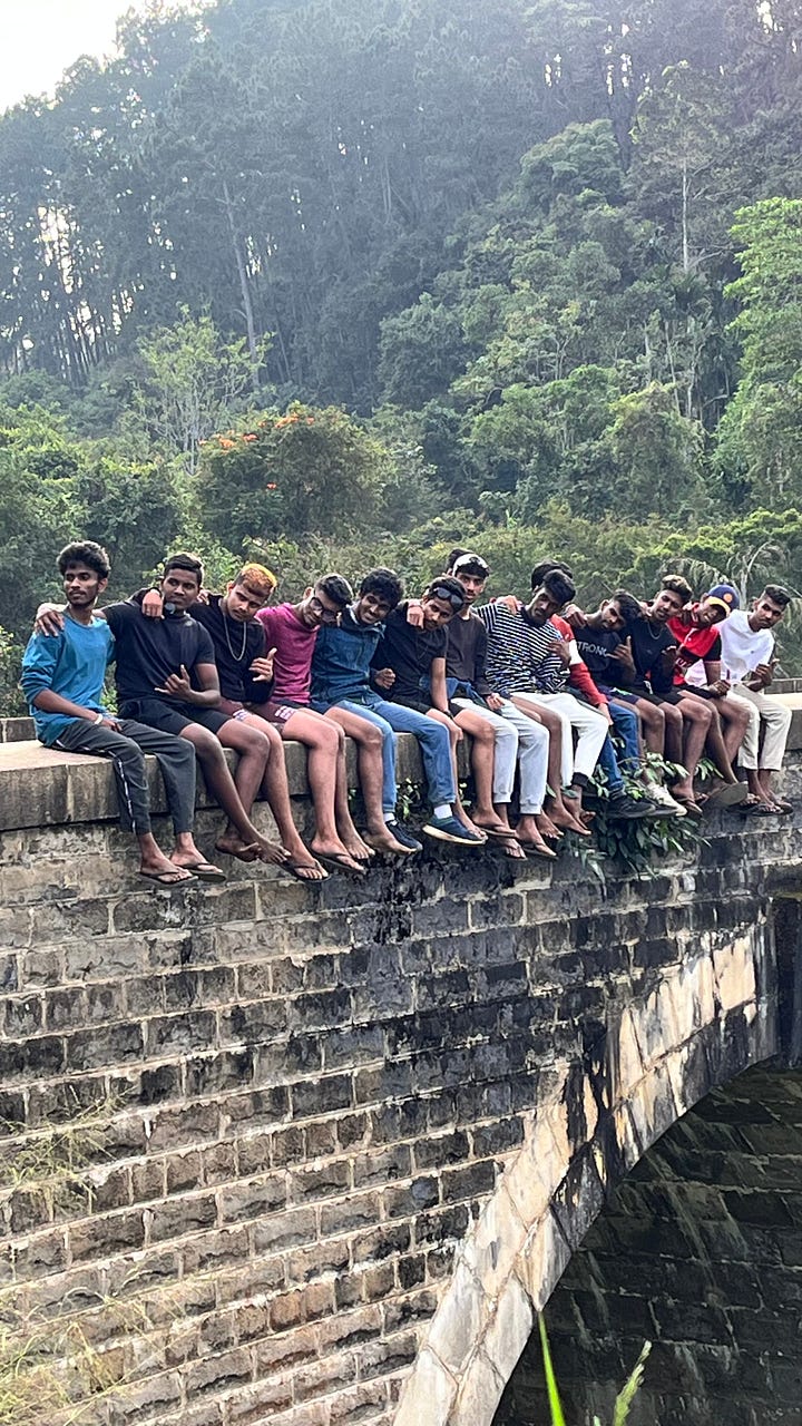 A bus and a group of young men posing for a photograph on a ridge