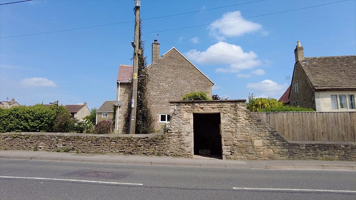 A bus shelter built of stone which inside hides an old village pump. Bath Road, Atworth, Wiltshire. Image: Roland's Travels