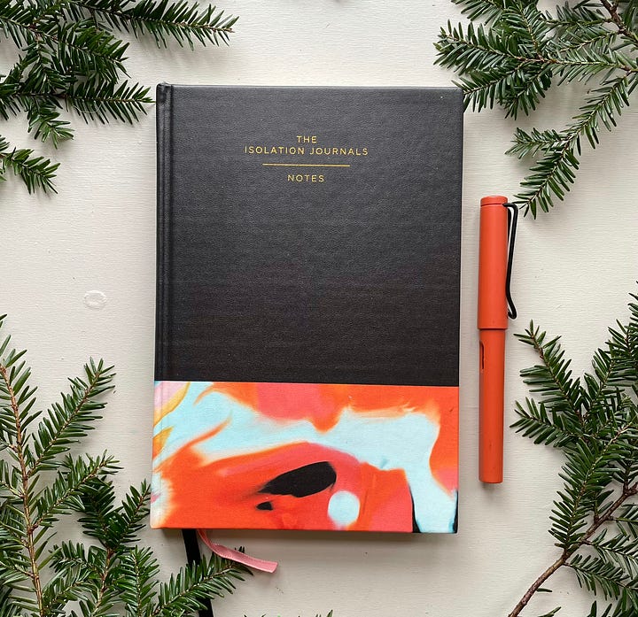 On the left, a custom Isolation Journal No. 1 (cover is a colorblock of black above a marbled strip of orange, seafoam green, and black); on the right, a figure holds the Surrender tote (four birds lifting a wooden marionette by its strings beside the mantra "I release control and surrender to the flow.")