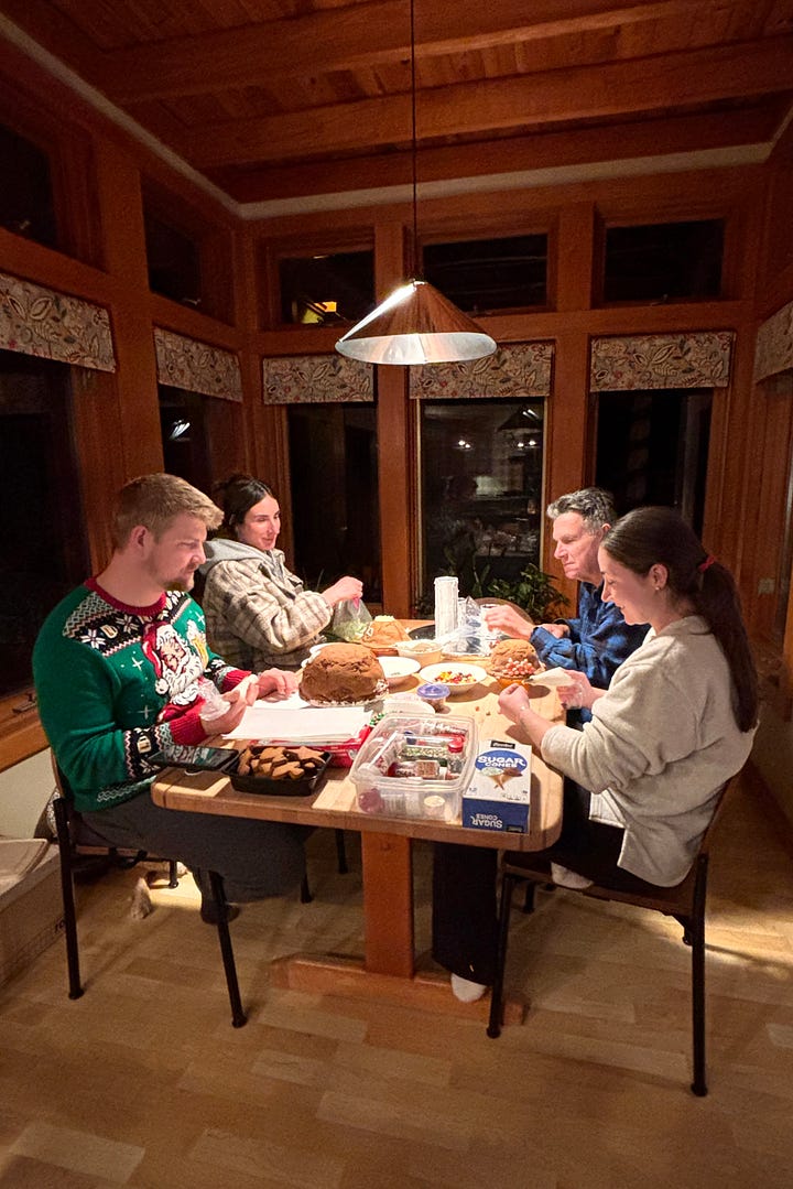 four family members decorating gingerbread 