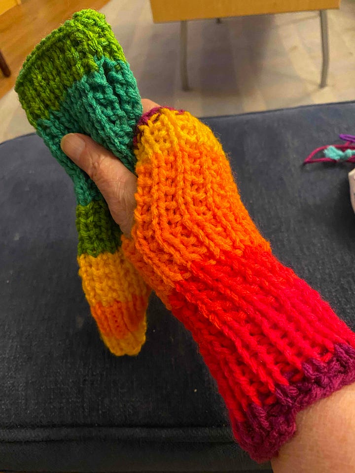 A scarf, hat and fingerless mitt in vibrant rainbow yarn.