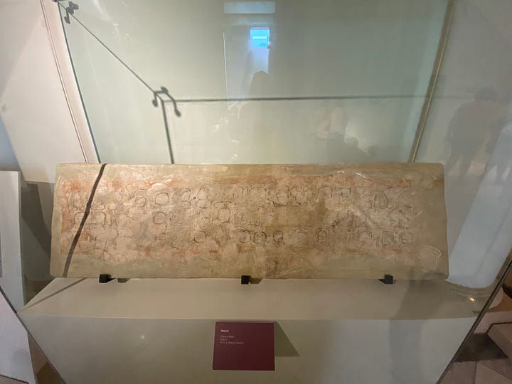 Ancient Mayan artifacts at the Museo Regional de Yucatán, Mérida. Clockwise from top left: A mural from Ek Balam. Statue of a female ruler, with our guide Alfonso. A cylinder vase. Man's head with headdress, Ek Balam.