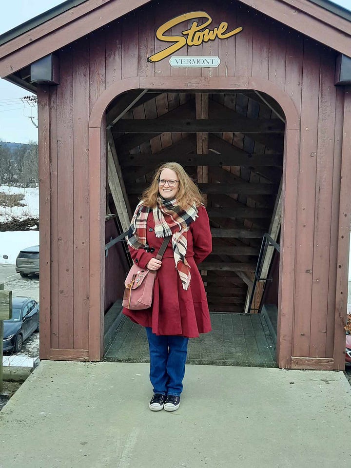 Amber, wearing a burgundy coat, (top L to bottom R) stands beside a sign for the Old Yard Cemetery, stands under a sign for the Green Mountain Inn, stands at the Stowe, Vermont covered-bridge style walkway, and stands beside a festive light post.