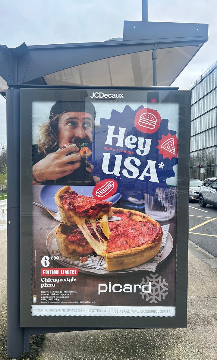 Shopping for frozen food in France. A billboard advertises Hey USA American foods in France, plus frozen food products on shelves in French grocery store