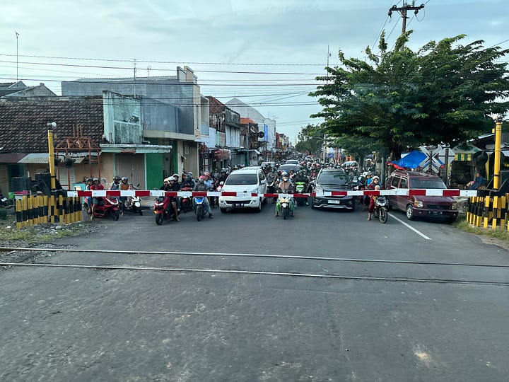Scooters lining up at Indonesian railroad crossings