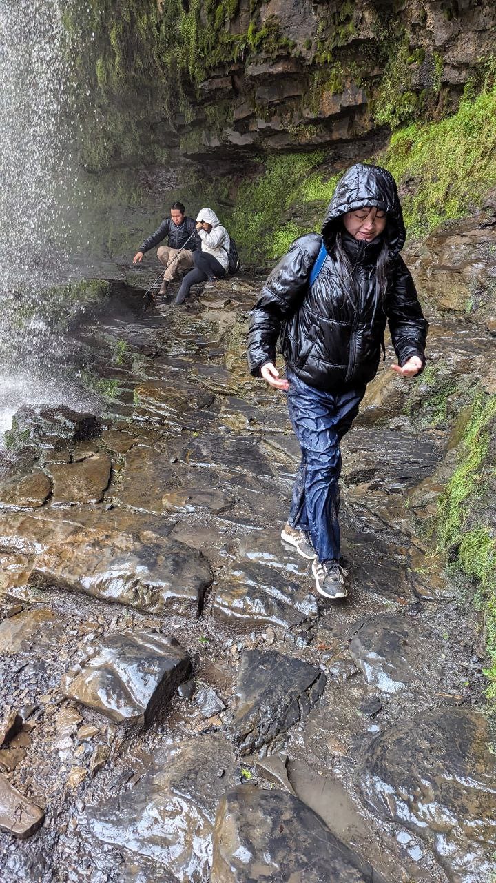 people smiling at the waterfalls of the brecon beacons