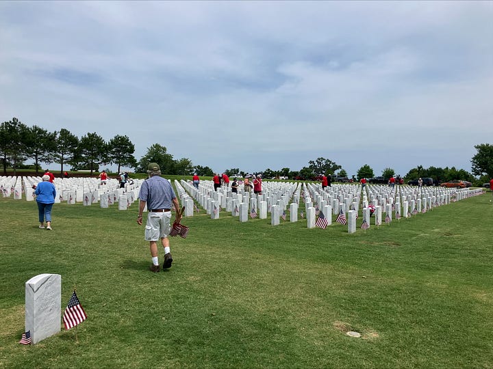 Veterans and local residents placing flags on gravesites at the Tallahassee National Cemetery