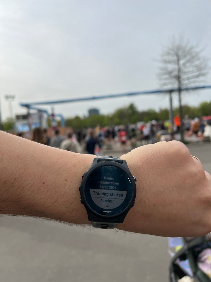 Auf dem ersten Bild ist meine Tochter Pippa im Kinderwagen mit einem Schild in der Hand „Papa, du bist mein Held“ und auf dem zweiten Bild die Laufuhr von Hannes mit der Aufschrift „Heute: Berliner Halbmarathon Berlin 2024, Training starten“