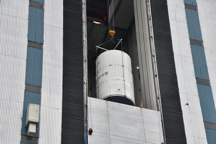 The Tianwen-2 probe, inside a protective casing, being lifted toward the top of the Long March 3B/E during launch preparations.