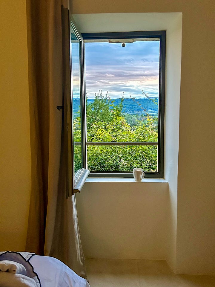 A farmhouse in Provence against a blue sky, a vue into the villa kitchen in Provence, and a window looking at a September sunrise in the south of France