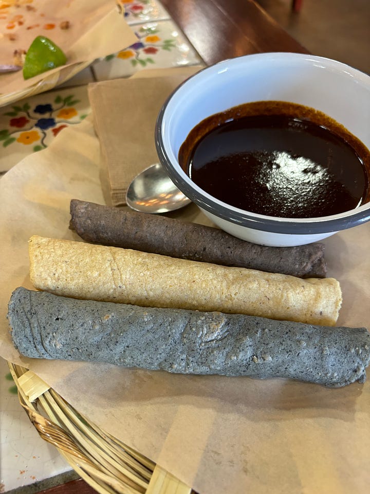 Nopales tlacoyos and tortillas with mole from Komal