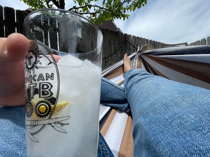 A can of Cayman Jack Margarita drink sitting next to a full pint glass on hot summery day.