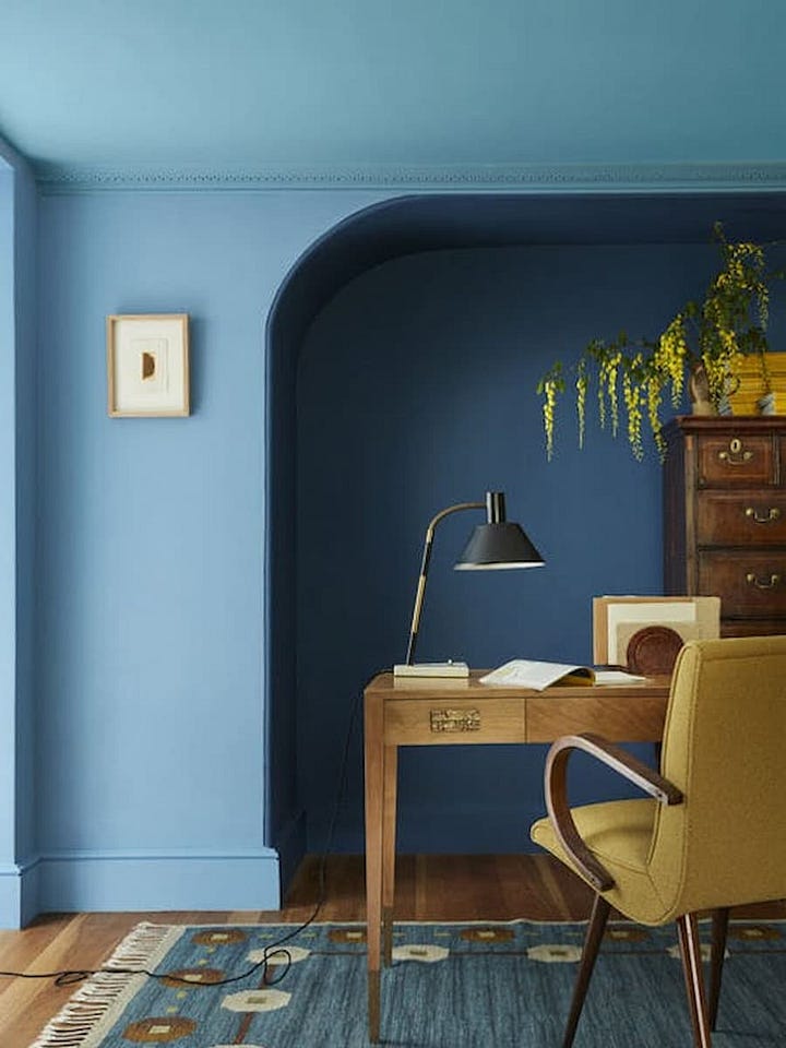 office space painted completely in shades of blue and living room painted in shades of green