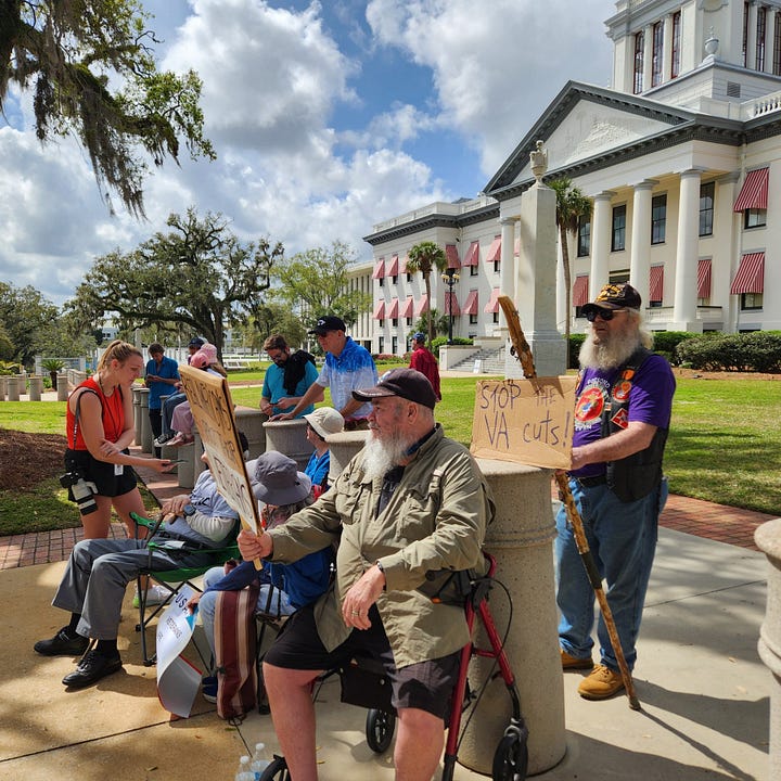 Veterans holding signs in protest of President Trump