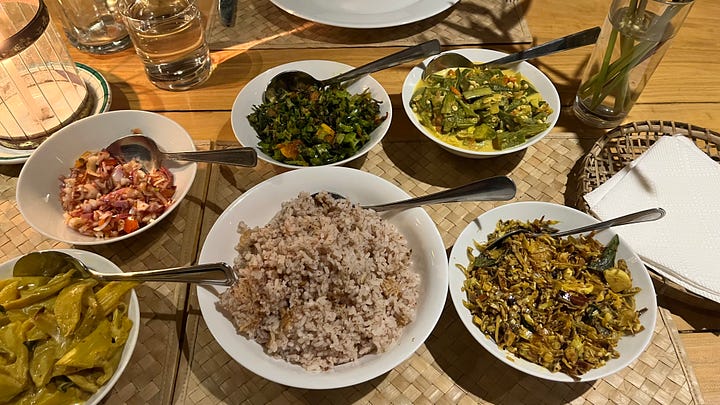 Idyllic beach with palm trees and a collection of small dishes containing rice and curry.