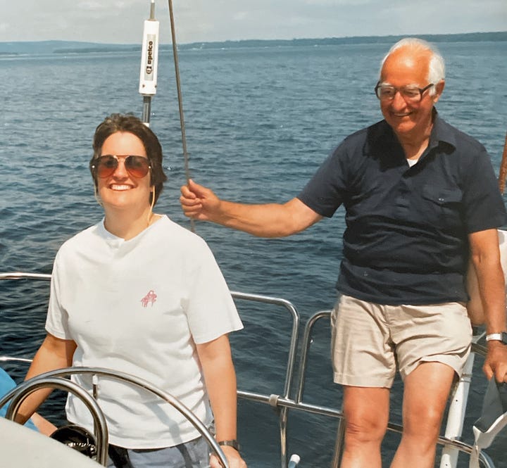 1. Two women standing with hills and water in the background and 2. a woman at the helm of a sailboat with a man smiling behind her