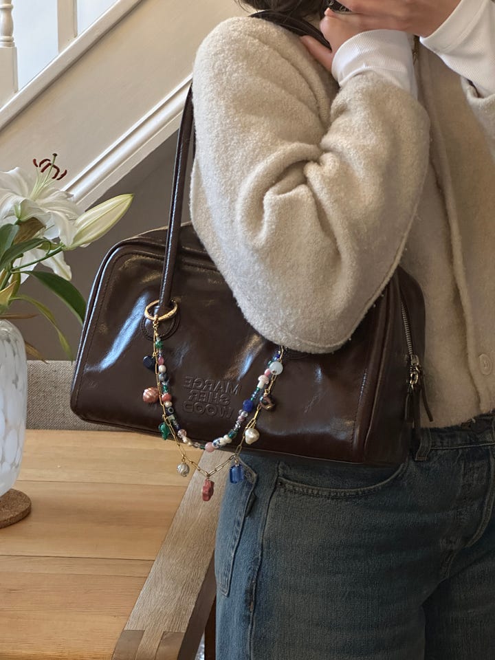 Left photo of light beige vintage trench coat. Right photo of Marge Sherwood Boston bag in brown with bag charm from playground garden.