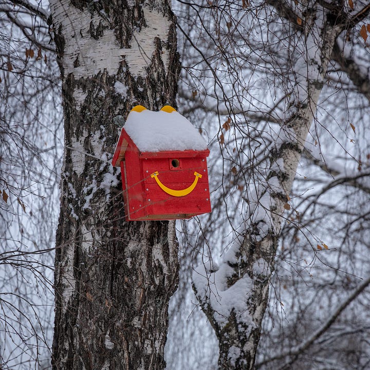 Postcards, the snow-covered drive thru, Happy Meal bird feeder, and poster from the McDonald's in Rovaniemi, Finland