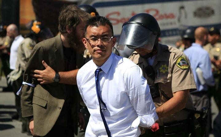 Wayne Hsiung, animal rights activist, being arrested and holding a piglet