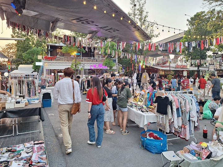 Guests relax with coffee in hand in the lush botanical garden at Victor 515. A airplane wing overhands the vintage clothing market at Chang Chiu Creative Park. 