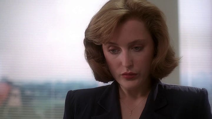 Scully looks at the Mulder family report, featuring frames depicting Fox and Samantha.