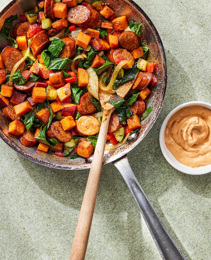 2 dinners- both with sausage and vegetables and a sauce, one in a skillet and one plated.