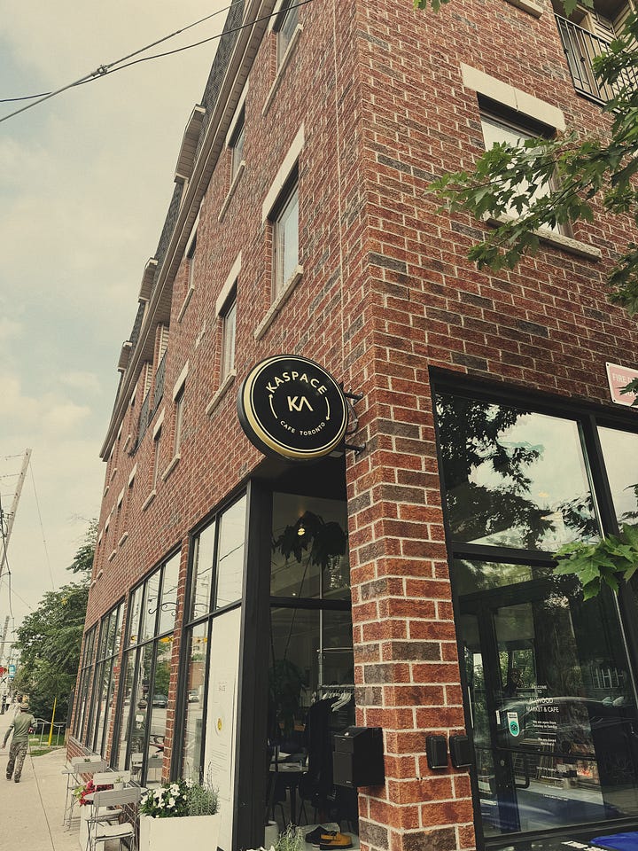 Two pictures of the exterior of a cafe. First picture is a window with the name Allwood Toronto on it. Second picture is the brick exterior.