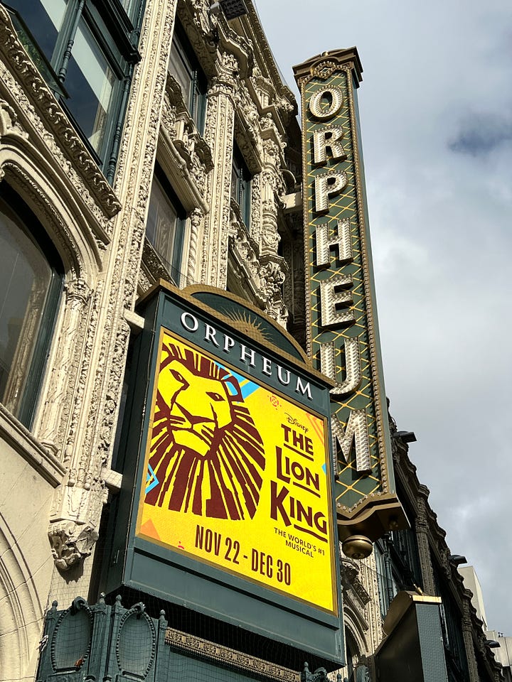 1: Image of Orpheum Theatre The Lion King marquee; 2: Image of 3 smiling people in front of The Lion King marquee; 3: Image of The Lion King playbill inside the theatre with the theatre curtain in the background; 4: image of 3 people - 1 with a mask, 2 without, in the theatre with the curtain behind them