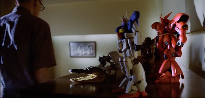 A collection of screenshots from the Somewhere I Belong music video featuring several small plastic models from different Gundam series.