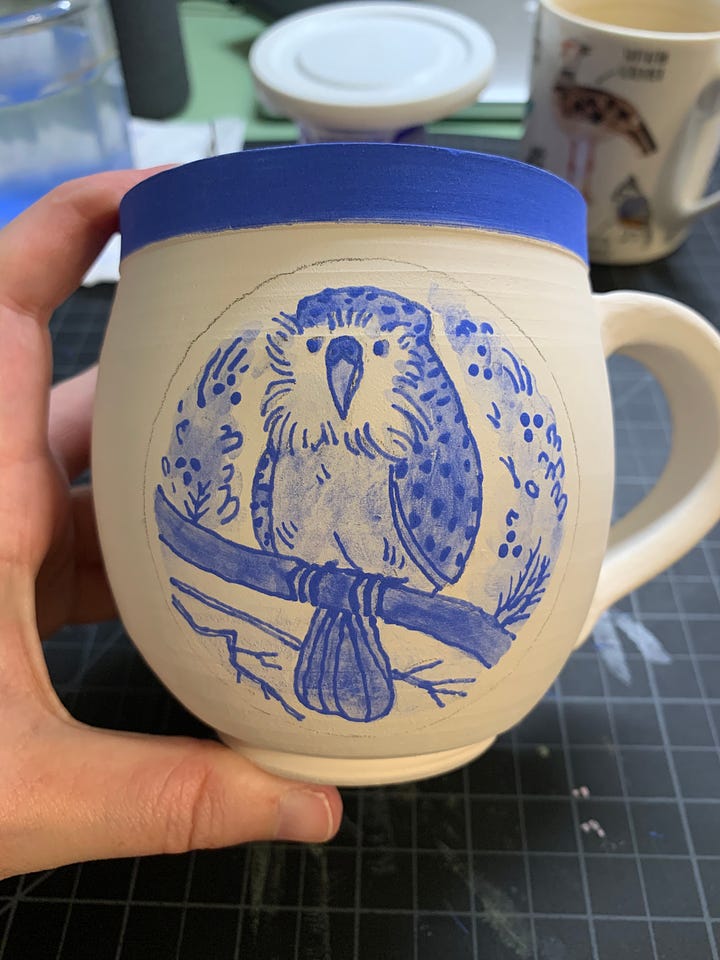 ceramic mugs and a saucer in different phases of the illustration process using underglaze and a slip trailer by Kayla Stark