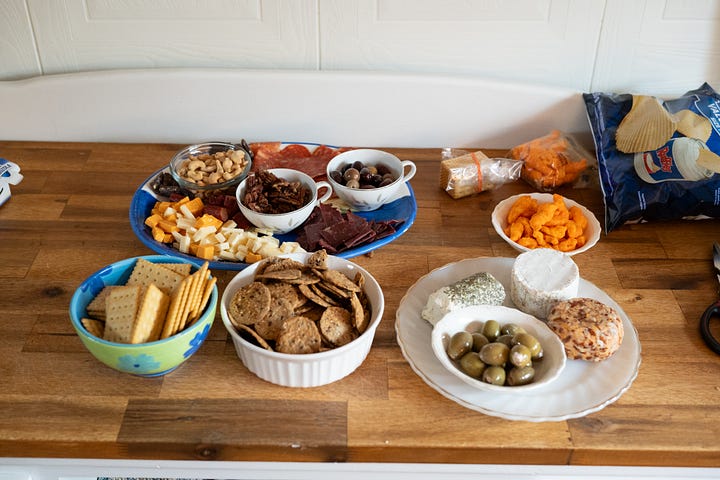 Charcuterie feast, Pic 2 the girls cheers at the table, pic 3 Cards against humanity covered in dust, pic 4 Don Julio tequila and some solo cup shot glasses 