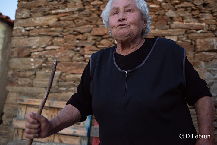 The photo shows an elderly woman in a small village in Portugal, 2023