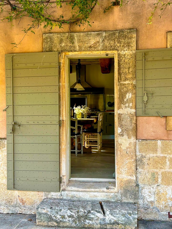 A farmhouse in Provence against a blue sky, a vue into the villa kitchen in Provence, and a window looking at a September sunrise in the south of France