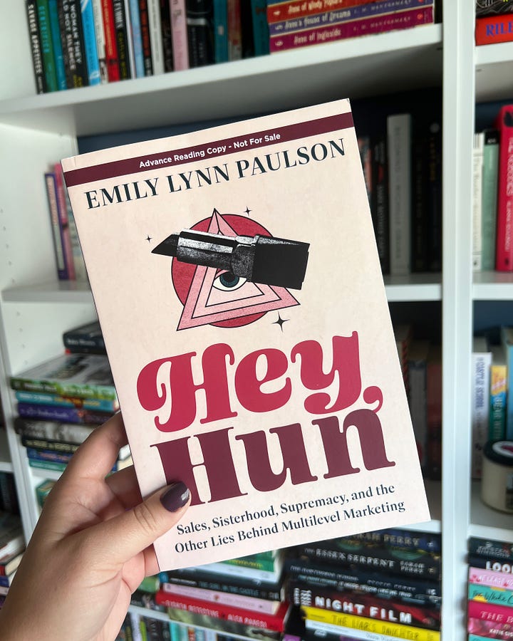 Left: A hand holding the book The Women Could Fly outside on a bright day, with a blue sky in background. Right: a hand holding a copy of Hey, Hun in front of packed bookshelves.