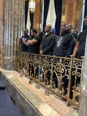 Men in black standing in Louisiana Senate chamber