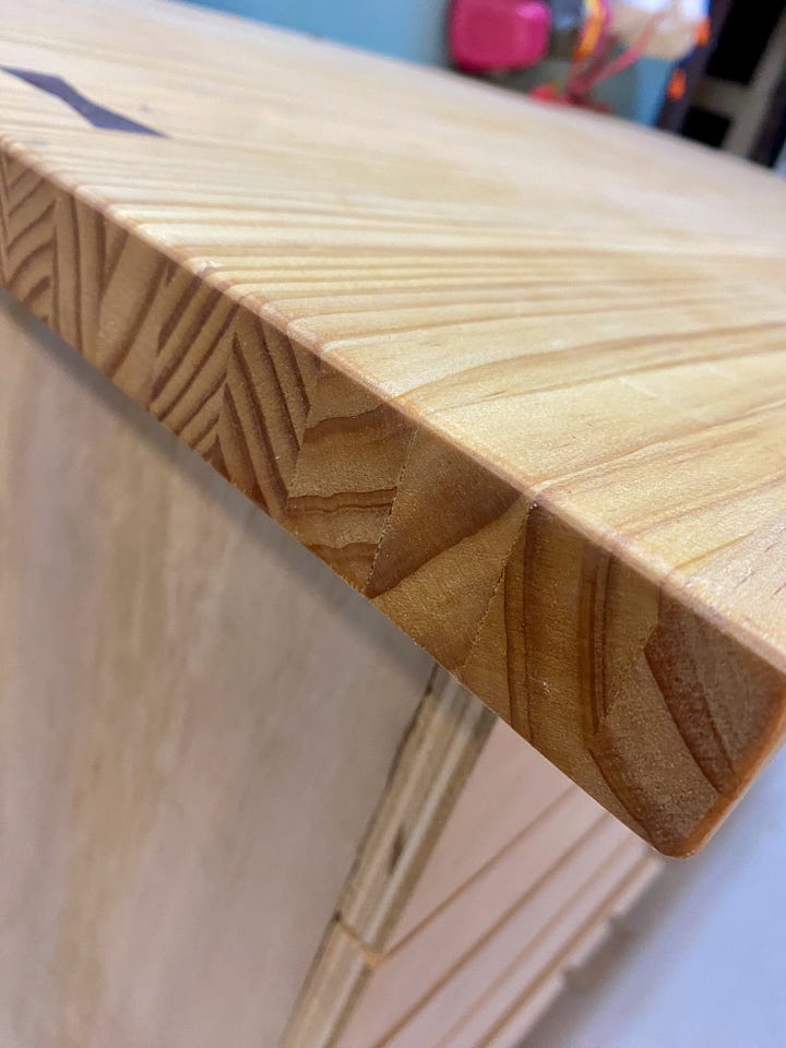 Heavy-duty caster wheels, laminated-pine top, walnut bow tie inlay, and full picture of a shop cabinet.