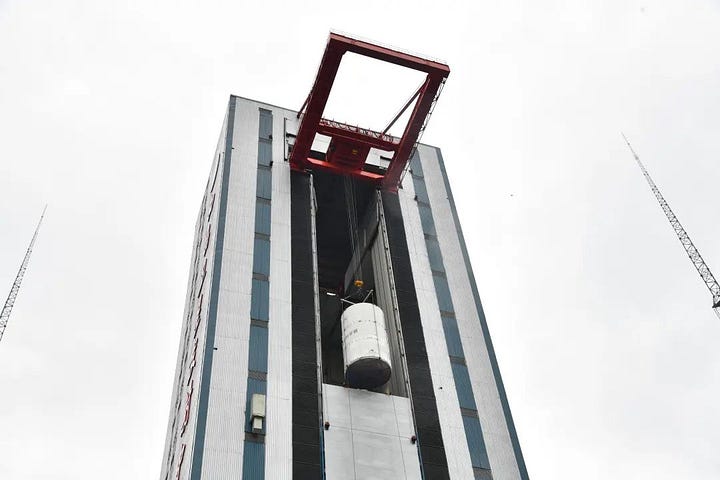 The Tianwen-2 probe, inside a protective casing, being lifted toward the top of the Long March 3B/E during launch preparations.