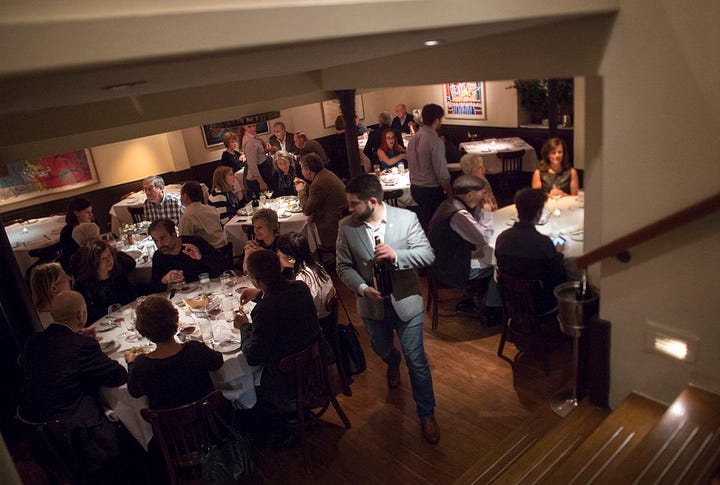 people in a restaurant in New York, a restaurant kitchen with plates, a busy dining room in a NYC restaurant