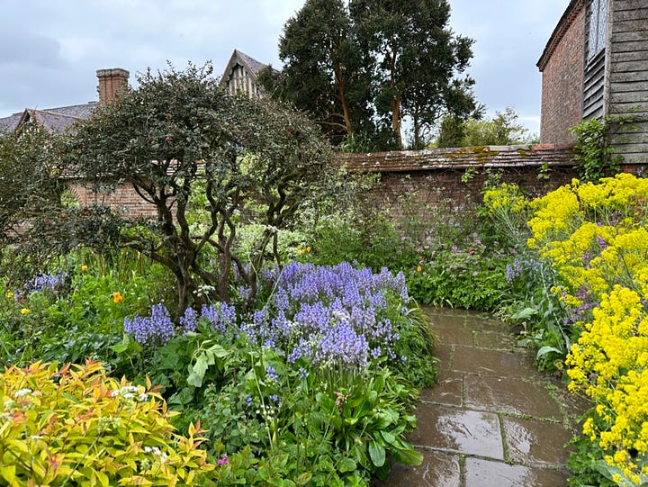 Iconic architectural elements from Great Dixter: the Lutyens circular steps from the terrace to the meadow, the porch with its pot display,  a corner of the Barn Garden, and the Lutyens steps and garden wall.