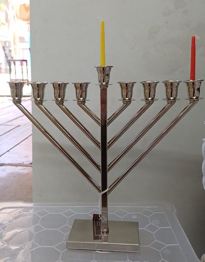 Two hanukiot (menorahs), one with the shammash plus one candle per Hillel, the second the shammash plus 8 candles per Shammai