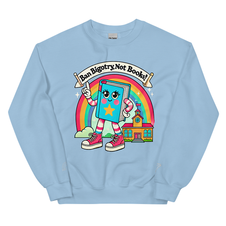 Two crewneck sweatshirts featuring a colorful design with a cartoon-style book character. The book has a smiling face, arms, and legs, wearing pink sneakers and waving a flag. Above the book, a banner reads "Ban Bigotry, Not Books!" in bold, playful font. The background features a rainbow and a small schoolhouse. One sweatshirt is pastel blue, while the other is light gray, both displaying the same vibrant illustration.