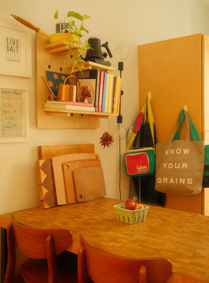 Kitchen with wooden table and shelving on the walls. 