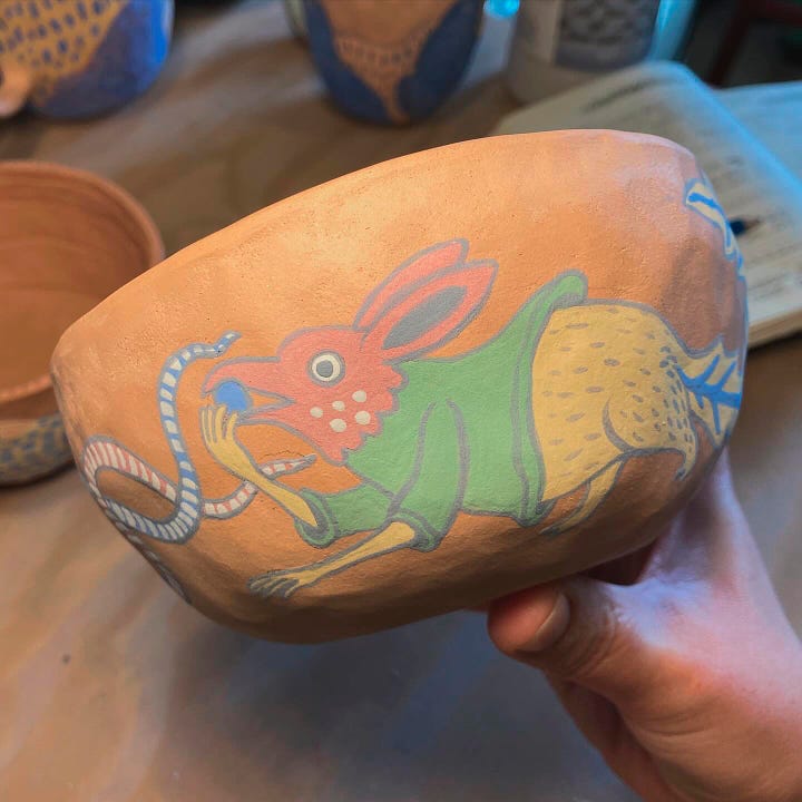 two pinch-pot bowls painted with designs inspired by medieval illuminated manuscript creatures