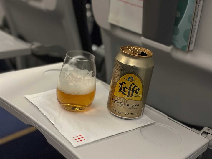 Brussels Airlines Airbus A319 aircraft and a beer on an airplane tray table.