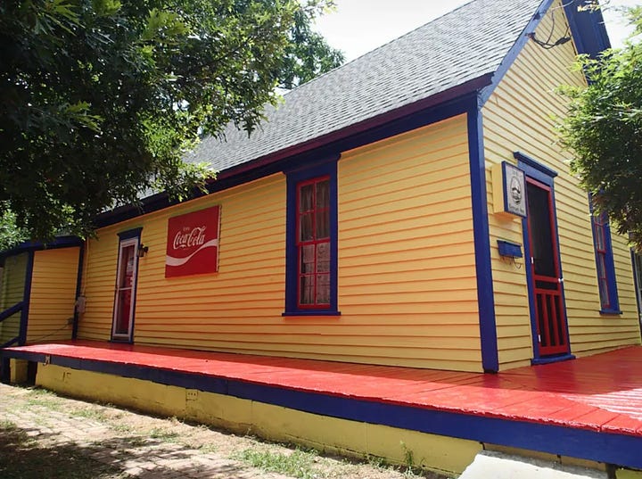 A house with fading paint on the left and, on the right, the same house, bright yellow, red patio, and blue and red trim after the volunteer crew did their work.