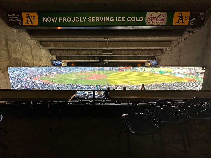 Exterior view of Coliseum from train station, and view from seat with blocked view due to seats on the level above.