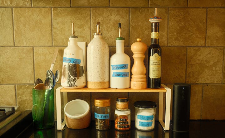 Kitchen stove and jars on a small shelf.