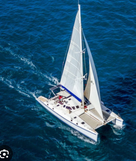 catamaran and monohulled sailing vessels both sailing upwind. 