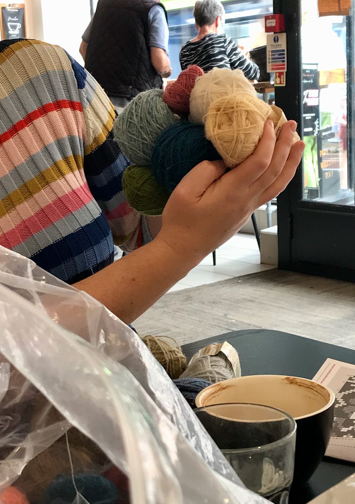 Lots of balls of Shetland wool on a table in a coffee shop