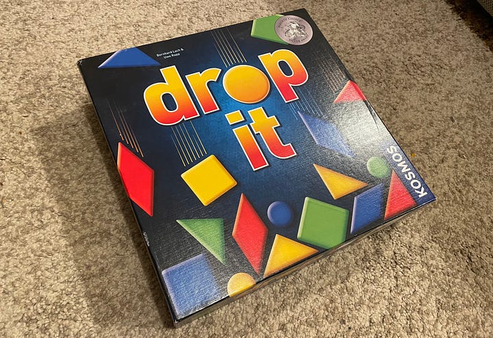 A game of Drop It in progress and the game box